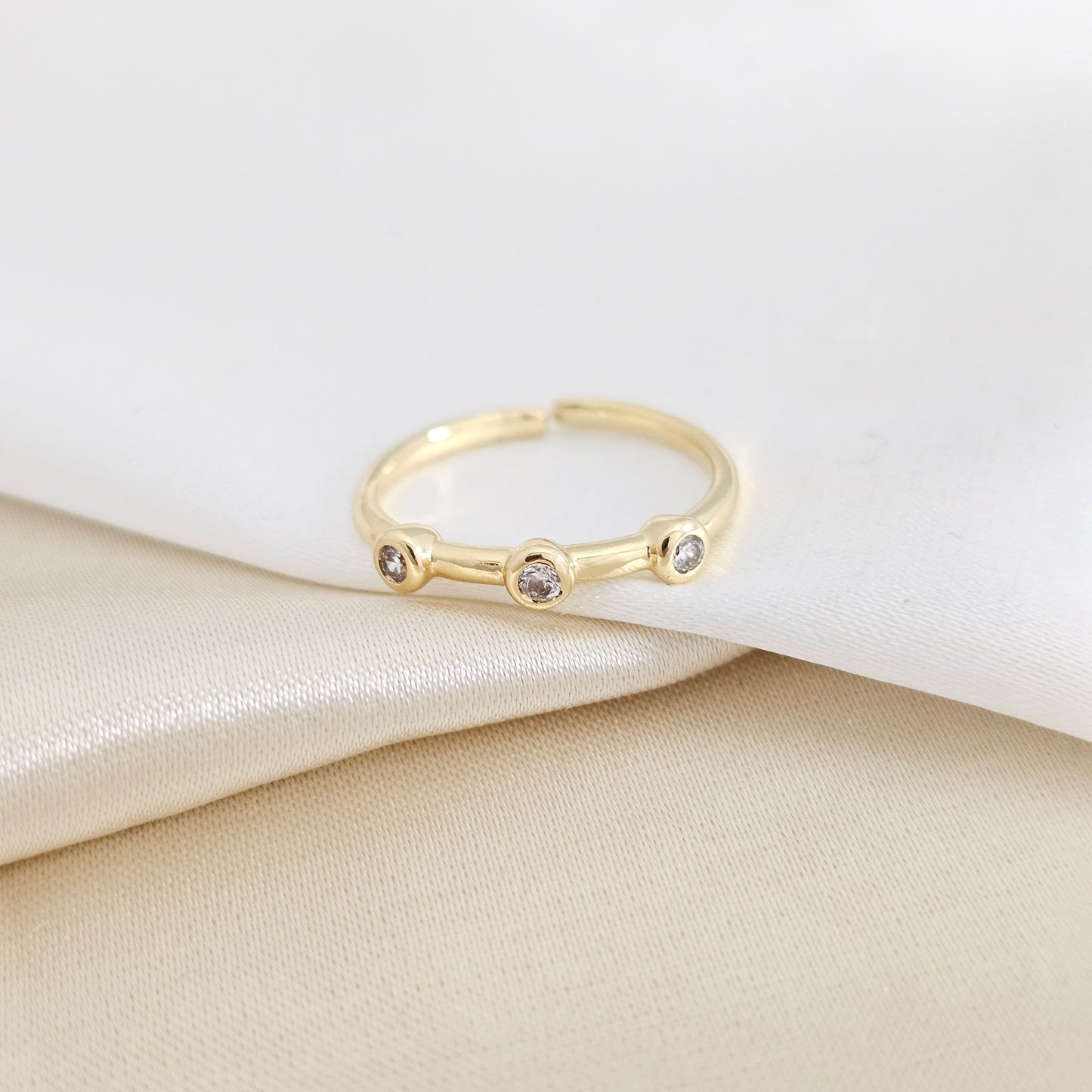 ANILLO LISO DORADO CON TRES CIRCONES RF K7930