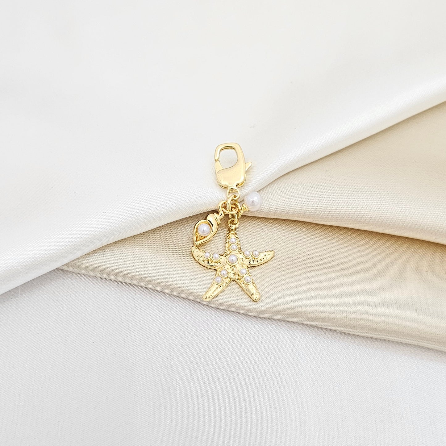 LLAVERO ESTRELLA DE MAR Y MINI CARACOL PERLAS DORADO RF K6937