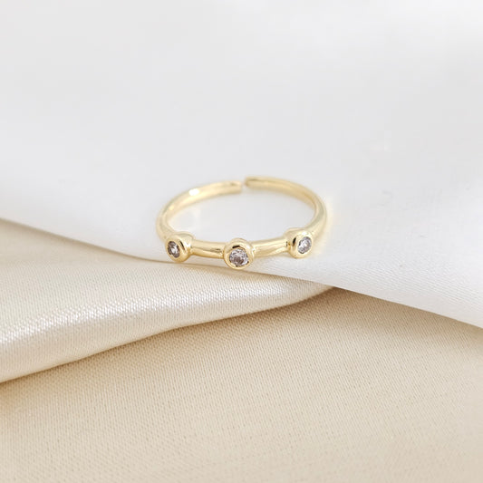 ANILLO LISO DORADO CON TRES CIRCONES RF K7930