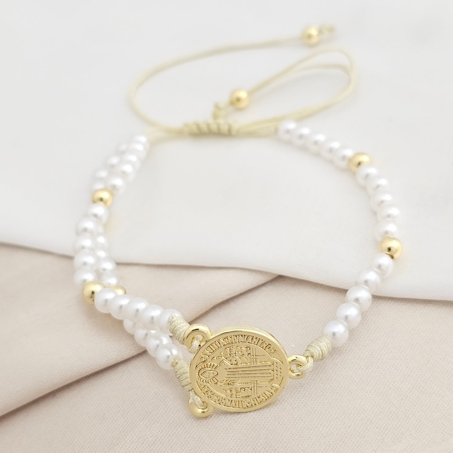 PULSERA BEIGE PERLAS Y BALINES DIJE SAN BENITO DORADO RF K8073